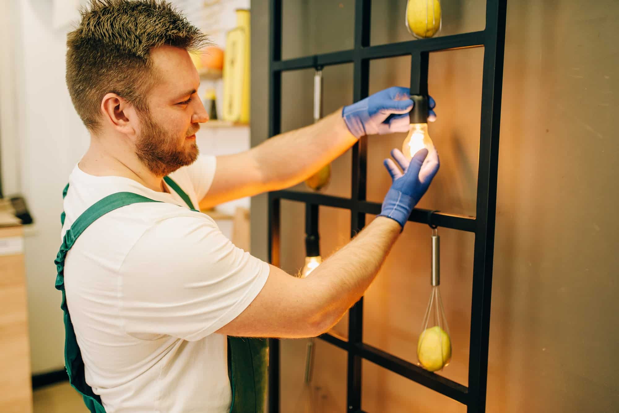 Electrician changes the light bulb, handyman