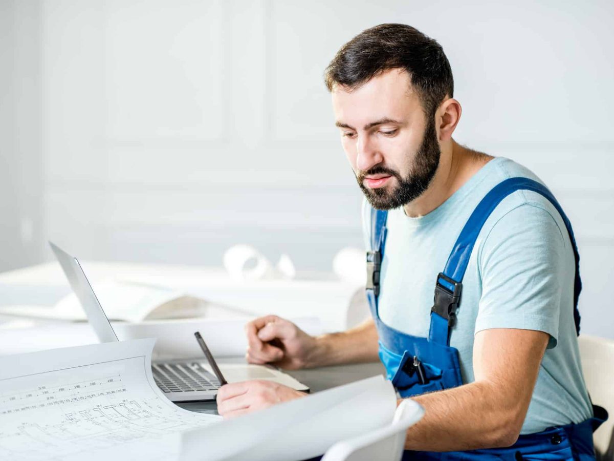 Repairman with paper drawings at the office